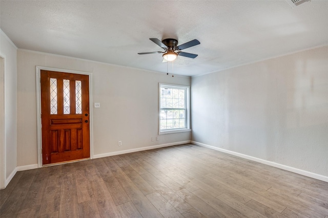 foyer with a textured ceiling, ceiling fan, crown molding, and light hardwood / wood-style flooring