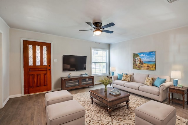 living room with wood-type flooring, ceiling fan, and ornamental molding