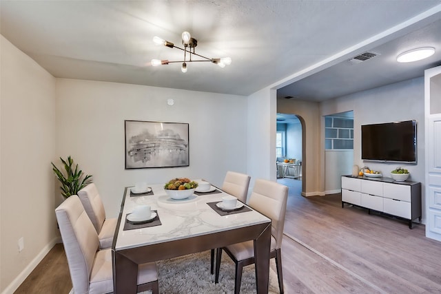 dining area featuring hardwood / wood-style flooring and a chandelier