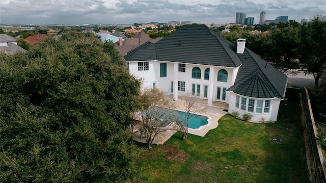 rear view of property featuring a patio area and a lawn