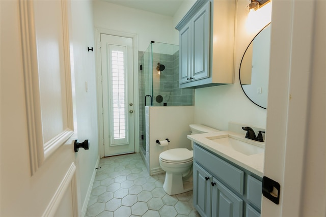 bathroom with tile patterned floors, vanity, an enclosed shower, and toilet