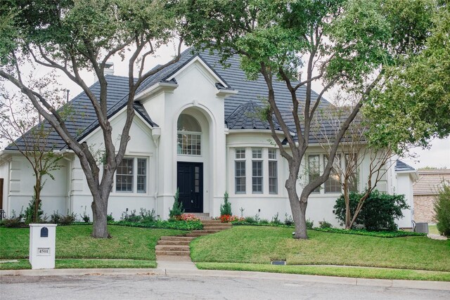 view of front of house with a front yard and central AC unit