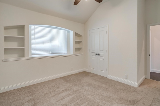 unfurnished bedroom with a closet, ceiling fan, lofted ceiling, and light colored carpet