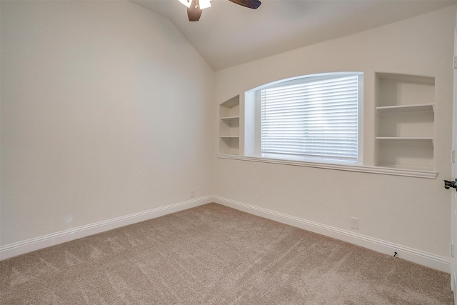 unfurnished room featuring built in shelves, ceiling fan, carpet, and lofted ceiling