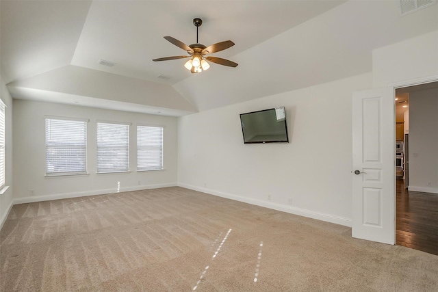 carpeted spare room featuring ceiling fan and vaulted ceiling