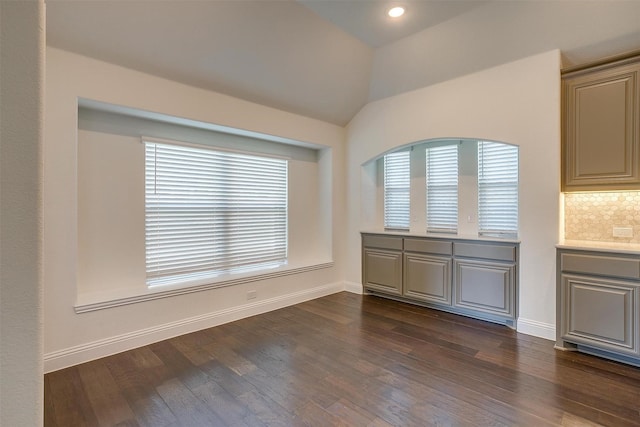 unfurnished dining area with dark hardwood / wood-style flooring and lofted ceiling