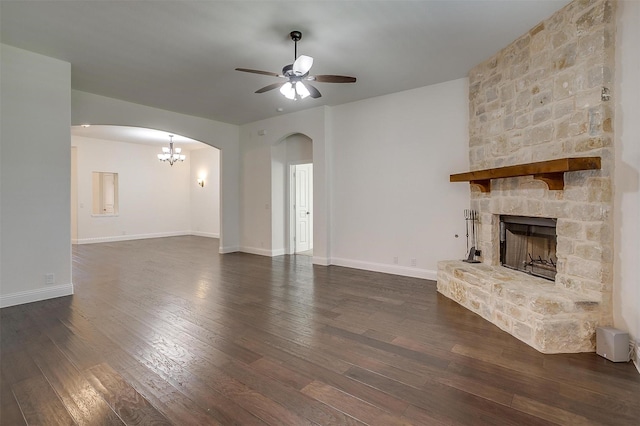 unfurnished living room featuring a stone fireplace, ceiling fan, and dark wood-type flooring