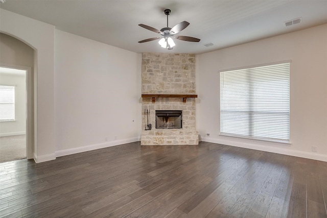 unfurnished living room featuring ceiling fan, dark hardwood / wood-style flooring, and a fireplace