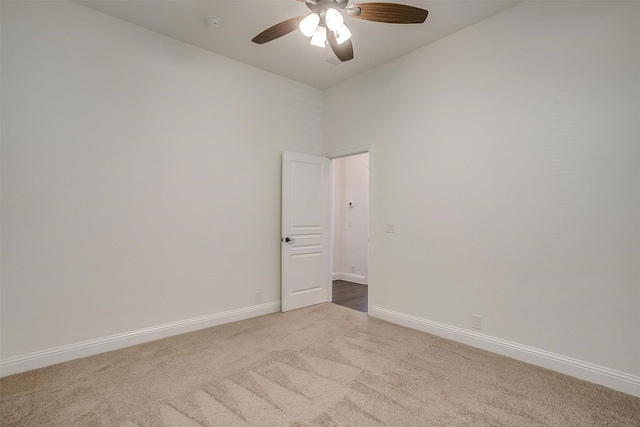 carpeted spare room featuring a high ceiling and ceiling fan