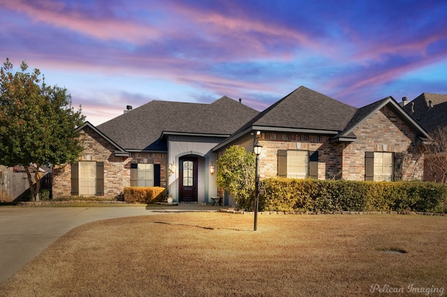 french provincial home with a yard