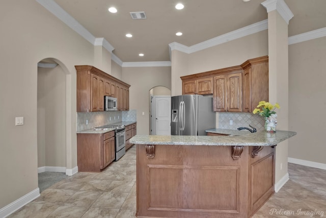 kitchen featuring crown molding, stainless steel appliances, light stone counters, tasteful backsplash, and kitchen peninsula