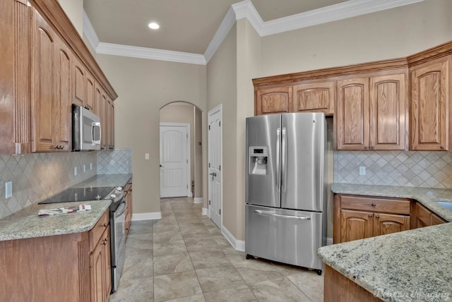 kitchen with light stone countertops, backsplash, ornamental molding, stainless steel appliances, and light tile patterned flooring