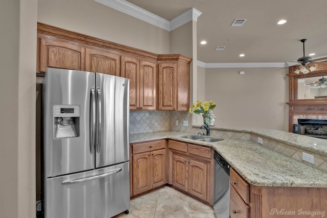 kitchen featuring light stone countertops, sink, kitchen peninsula, crown molding, and appliances with stainless steel finishes