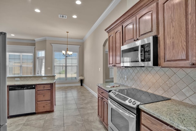 kitchen with light stone countertops, appliances with stainless steel finishes, and ornamental molding