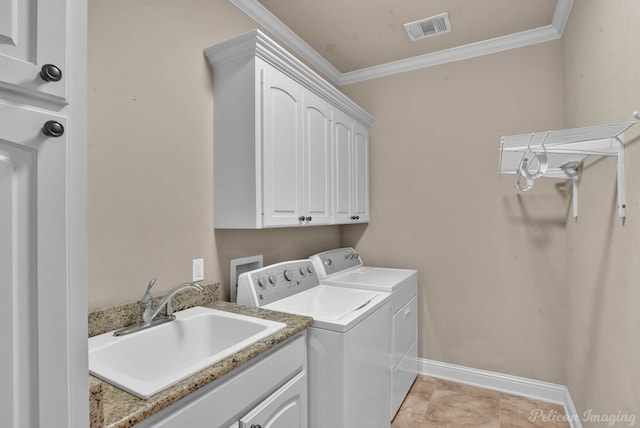 washroom with cabinets, ornamental molding, sink, and washing machine and clothes dryer