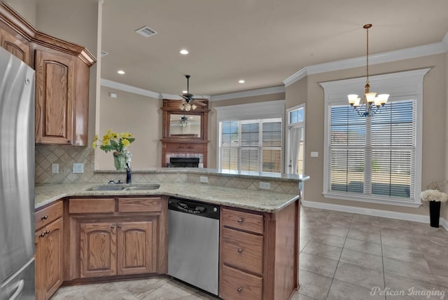 kitchen with appliances with stainless steel finishes, sink, light stone counters, kitchen peninsula, and crown molding