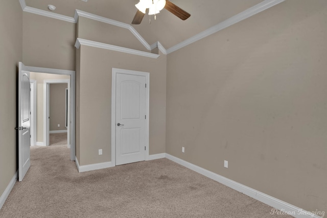 unfurnished bedroom featuring ceiling fan, crown molding, light carpet, and vaulted ceiling