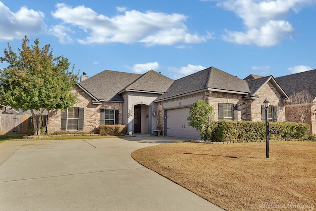 french country home with a garage and a front yard