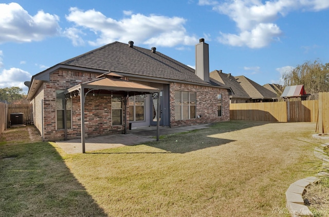 rear view of house featuring a gazebo, a patio area, and a lawn