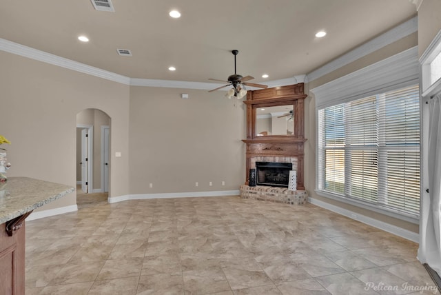 unfurnished living room featuring ceiling fan, ornamental molding, and a fireplace