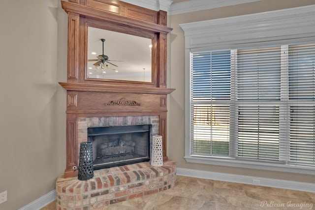 interior details featuring a brick fireplace, ceiling fan, and crown molding