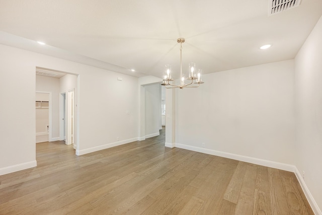 unfurnished room with light hardwood / wood-style flooring and a notable chandelier