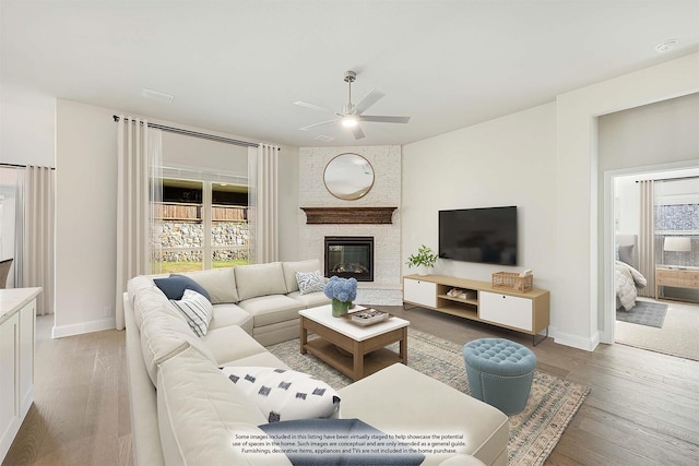 living room featuring a fireplace, ceiling fan, plenty of natural light, and hardwood / wood-style flooring