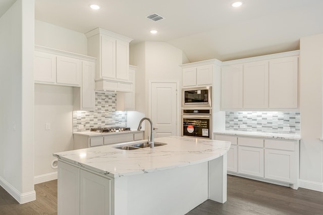 kitchen featuring appliances with stainless steel finishes, sink, a center island with sink, white cabinets, and lofted ceiling