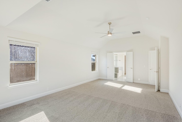 carpeted spare room with ceiling fan and vaulted ceiling