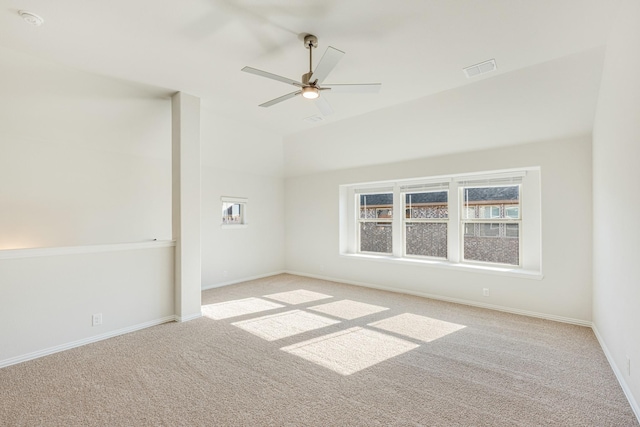 carpeted spare room featuring vaulted ceiling and ceiling fan