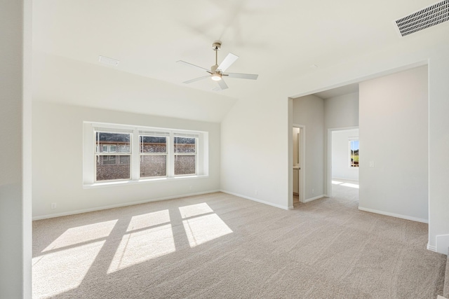 spare room featuring ceiling fan, light carpet, and lofted ceiling