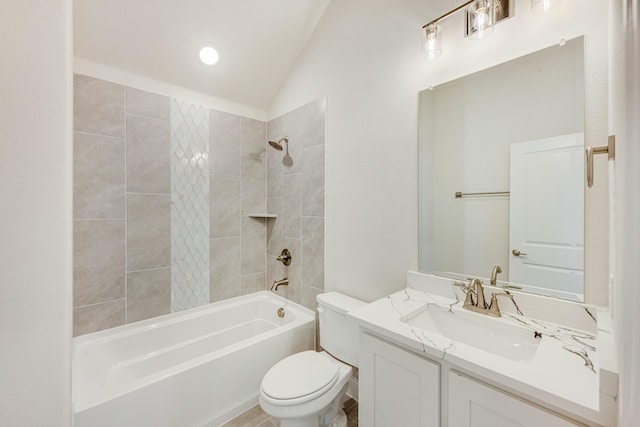 full bathroom featuring toilet, vanity, lofted ceiling, and tiled shower / bath