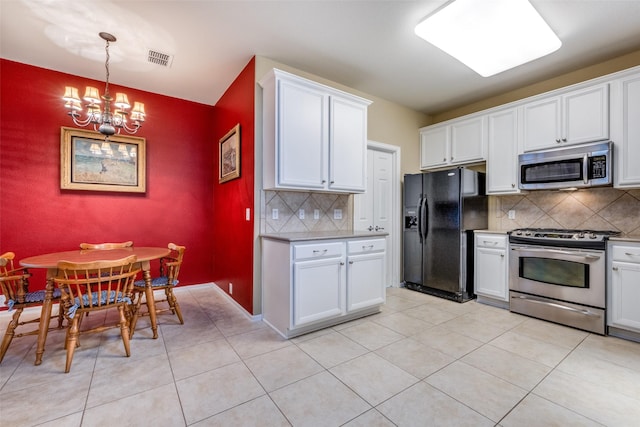 kitchen featuring white cabinets, a notable chandelier, appliances with stainless steel finishes, and tasteful backsplash