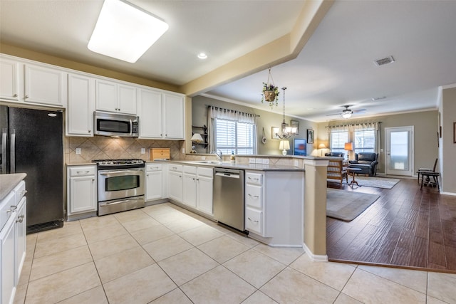 kitchen with pendant lighting, plenty of natural light, light wood-type flooring, and appliances with stainless steel finishes