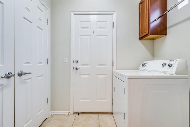 clothes washing area with cabinets and light tile patterned flooring