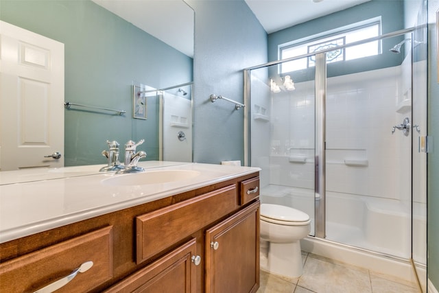 bathroom with tile patterned floors, vanity, toilet, and a shower with shower door