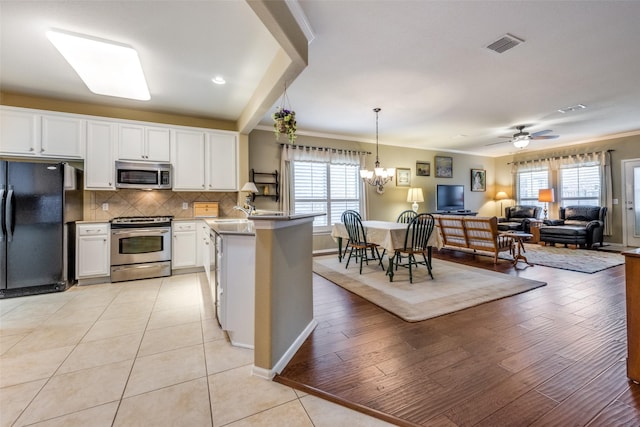 kitchen with white cabinetry, plenty of natural light, light hardwood / wood-style flooring, and appliances with stainless steel finishes