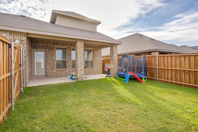 333 Pasture Dr, Midlothian, TX 76065 - back of house with brick siding, a trampoline, a fenced backyard, and a patio