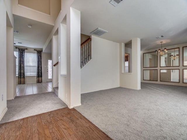 unfurnished living room featuring a chandelier and light hardwood / wood-style flooring