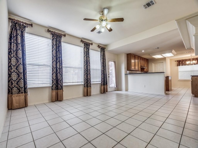 unfurnished living room with ceiling fan, light tile patterned flooring, and a healthy amount of sunlight