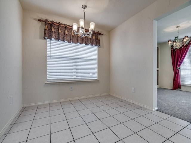 tiled empty room featuring an inviting chandelier