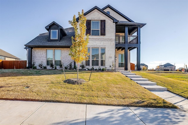 view of front of home featuring a balcony and a front lawn