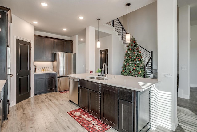 5214 Rowlan Row, Midlothian, TX 76065 - kitchen featuring appliances with stainless steel finishes, light wood finished floors, light countertops, dark brown cabinets, and hanging light fixtures