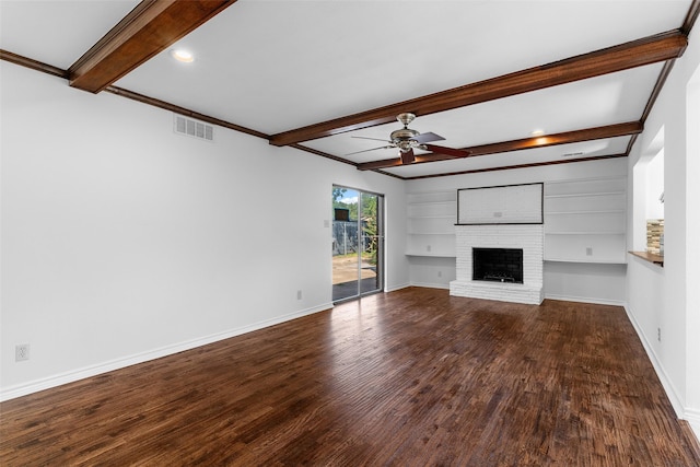 unfurnished living room featuring beamed ceiling, wood-type flooring, a brick fireplace, and ceiling fan