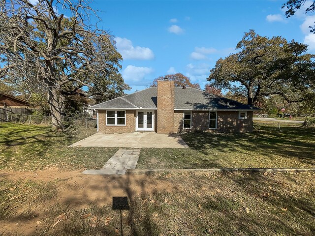 rear view of house with french doors, a yard, and a patio area