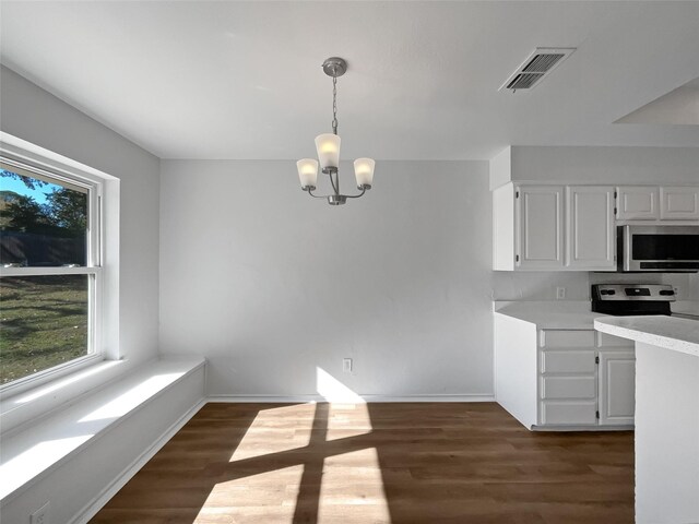 kitchen featuring decorative light fixtures, appliances with stainless steel finishes, a notable chandelier, dark hardwood / wood-style flooring, and white cabinetry