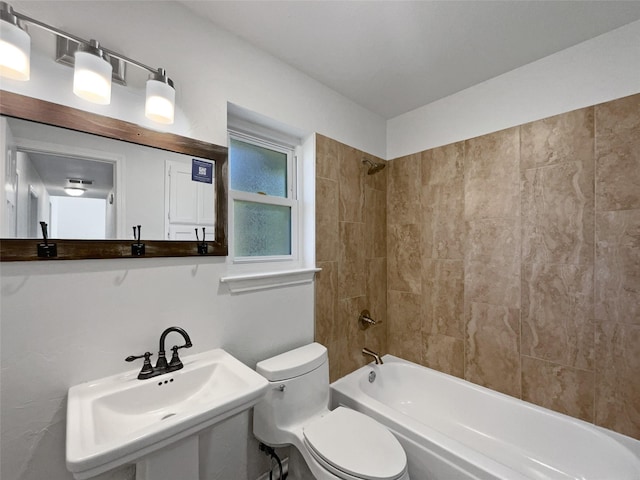 full bathroom featuring toilet, tiled shower / bath, and sink