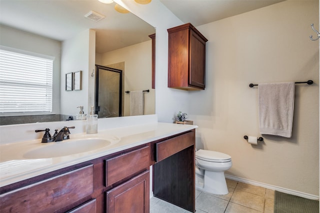 bathroom featuring tile patterned flooring, vanity, toilet, and walk in shower