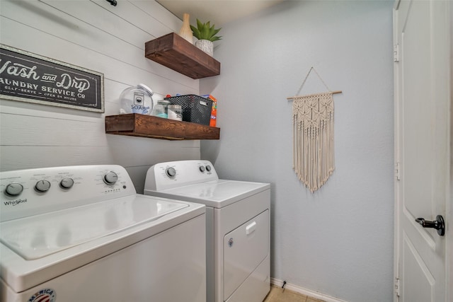 laundry room with washing machine and dryer and wood walls