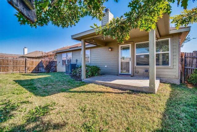 back of property with central air condition unit, a patio, and a yard